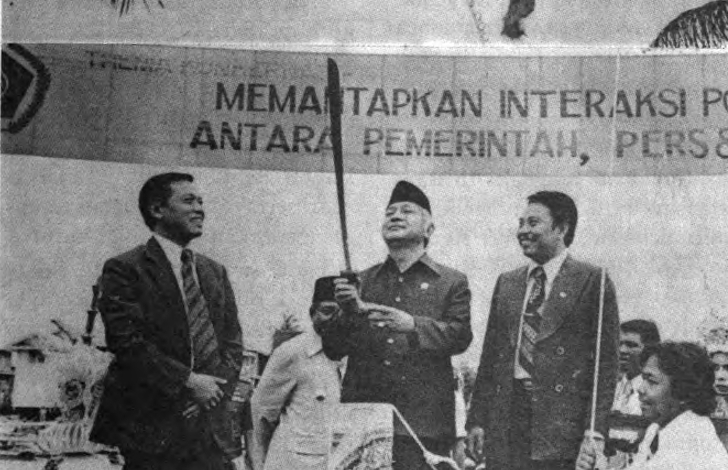 memutuskan tali balon sebagai tanda dibukanya Konkernas PWI. Ketua PWI Pusat Harmoko, Gubernur Kalsel Mistar Tjokrokoesoemo (latar belakang) dan Ketua PWI Cabang Kalsel/Ketua Panitia , H. Adenansi, menyaksikan upacara tersebut. Sumber Foto : Majalah Pers Indonesia Edisi April 1981