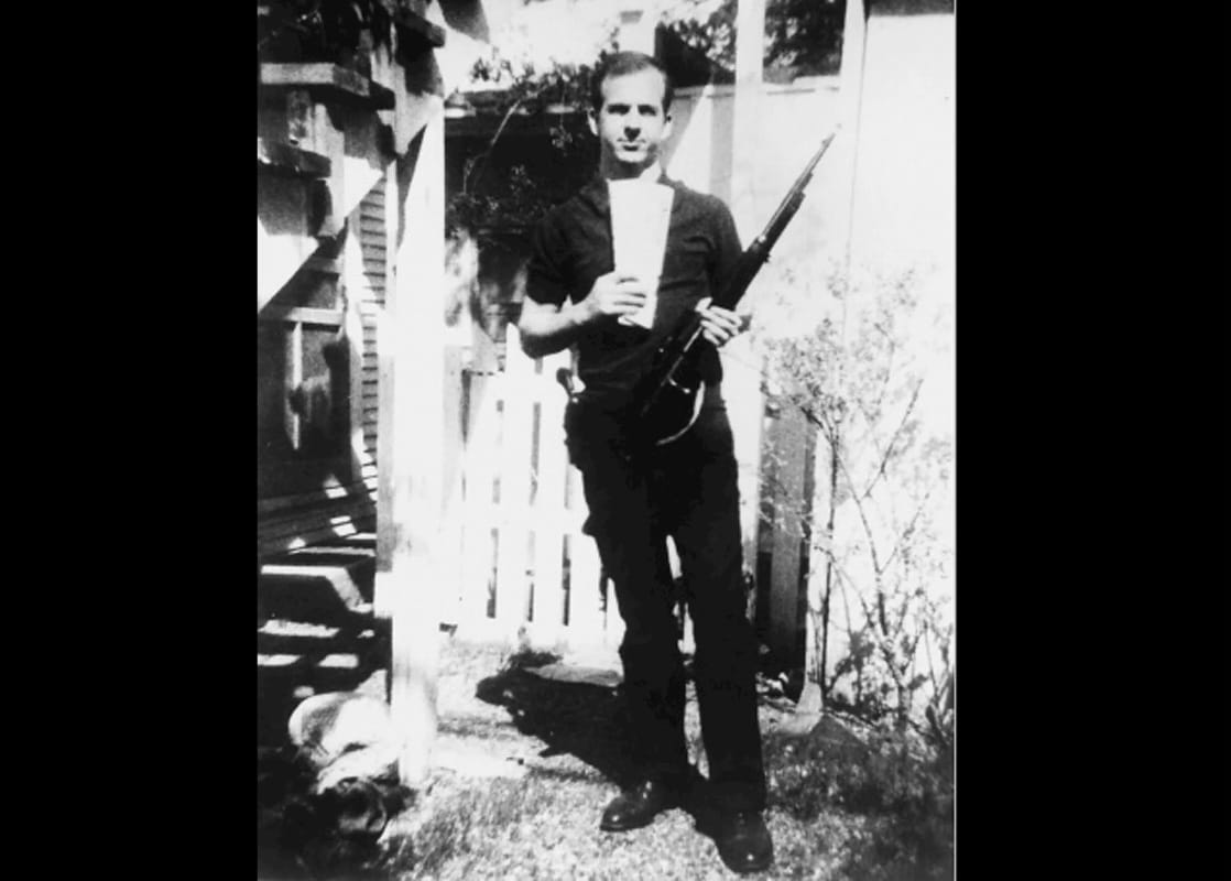 Lee Harvey Oswald, pelaku penembakan John F. Kennedy, memegang koran Rusia dan senapan yang dia beli melalui pos. Oswald pernah pergi ke Uni Soviet dan bertemu dengan agen KGB. (Sumber: Britannica)