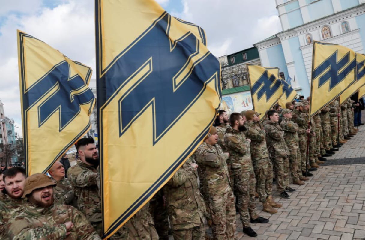 Anggota batalion Azov menghadiri rapat umum pada Hari Relawan untuk menghormati para pejuang yang bergabung dengan angkatan bersenjata Ukraina selama konflik militer di wilayah timur negara itu, di pusat kota Kyiv. (Sumber: The Jerusalem Post)