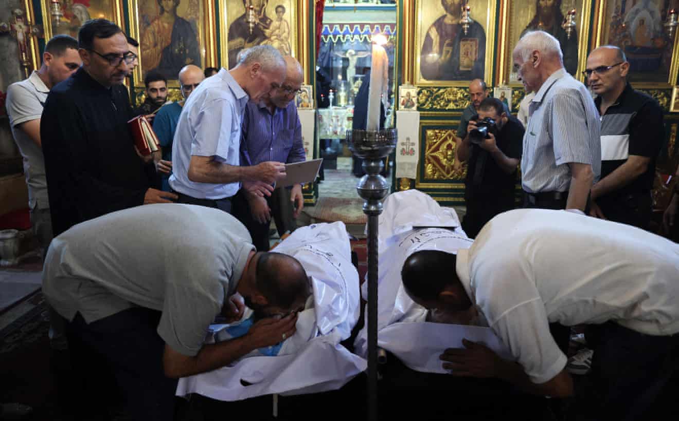 Umat Kristen Palestina berduka atas kematian Saad Salameh dan Fumayya Ayyad selama upacara pemakaman mereka di Gereja Santo Porphyrius di Kota Gaza. (Sumber: The Guardian)