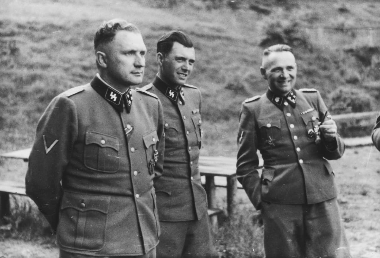 Auschwitz, Polandia. Tiga perwira SS bersosialisasi di halaman retret SS di luar Auschwitz, di "Solahütte", 1944. Dari kiri ke kanan, mereka adalah: Richard Baer (Komandan Auschwitz), Dr. Josef Mengele, dan Rudolf Hoess (mantan Komandan Auschwitz). (Sumber: Wikimedia Commons)